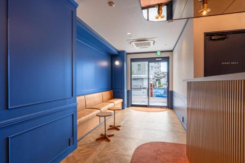 a blue room with a bench and a table at HOTEL KOMACHI TOKYO Higashi Nippori in Tokyo