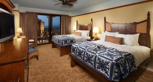 a hotel room with two beds and a flat screen tv at Aulani, Disney Vacation Club Villas in Kapolei