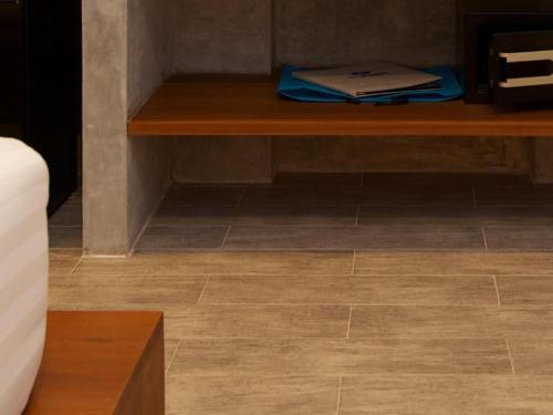 a wooden table in a room with a tile floor at Thalassa Hotel in Koh Tao