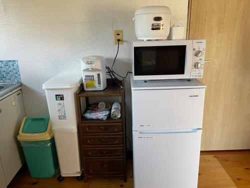 a kitchen with a microwave on top of a refrigerator at Sakitsu house SEI - Vacation STAY 51020v in Amakusa