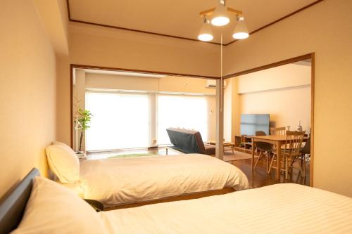a bedroom with two beds and a dining room at RIVER WEST Hiroshima 302, 305, 306 - Vacation STAY 54100v in Ōsukachō