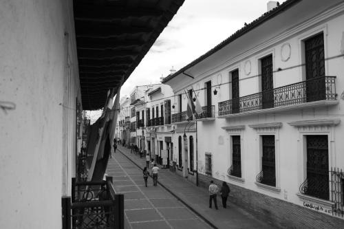 a black and white photo of people walking down a street at Hotel El Cid Plaza Premium in Tunja