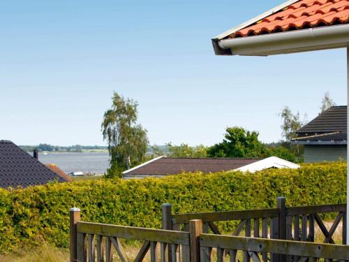a wooden fence in front of a hedge at 6 person holiday home in Jægerspris-By Traum in Frederikssund