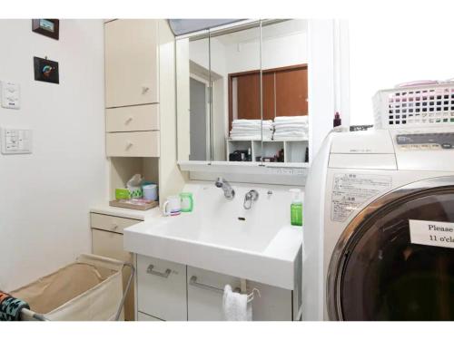 a bathroom with a sink and a washing machine at Art Salon Hosokawa - Vacation STAY 13628 in Sapporo