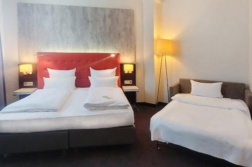 a hotel room with two beds and two lamps at Garner Hotel Berlin - Mitte by IHG in Berlin