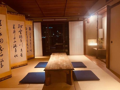 a room with a wooden table and blue mats at Kyoto Mizunagian - Vacation STAY 79553v in Kyoto