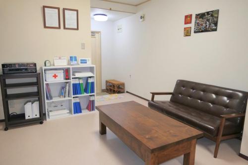 a living room with a leather couch and a coffee table at Aoisora Aoiumi no guest house - Vacation STAY 74840v in Takamatsu