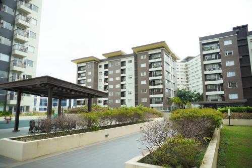 a park with a pavilion in front of some buildings at Cozy 2 Bedroom Condo with Balcony for Rent in Iloilo City