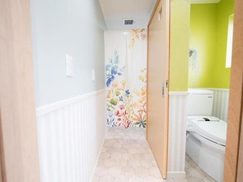 a bathroom with a toilet and a colorful wall at Villa East Hana - Vacation STAY 76042v in Nago