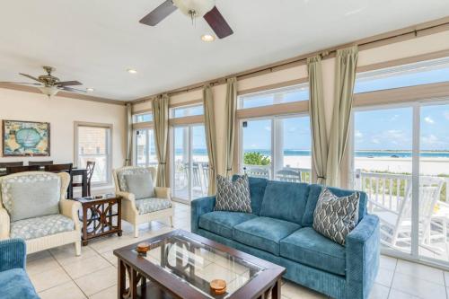 a living room with a blue couch and chairs and windows at A Pirate's Paradise in St. Augustine