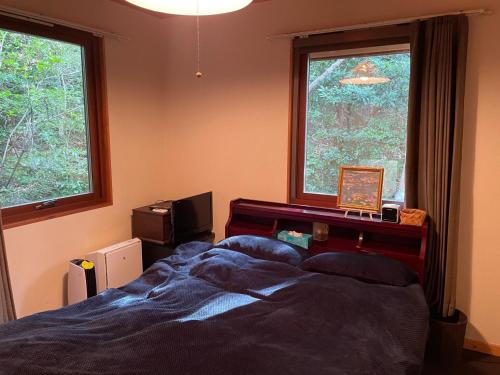une chambre avec un lit et deux fenêtres dans l'établissement Yamagoya limelight - Vacation STAY 79313v, à Okawa