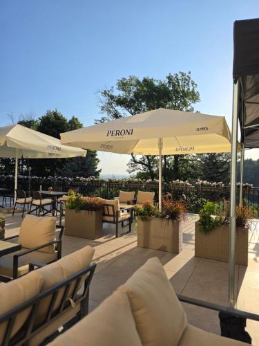 a patio with tables and chairs and umbrellas at Hotel Le Mont Medical & SPA in Świeradów-Zdrój