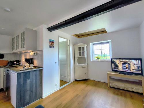 ØstermarieにあるAppartement Solbakkeの白い壁とウッドフロアのキッチン、窓が備わります。