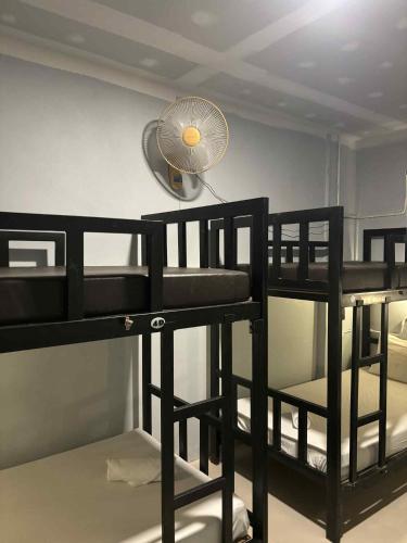 a room with two bunk beds with a fan at The Sunshine hostel and hotel in Ko Lanta