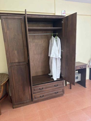 a wooden cabinet with a dresser and a robe at The Sunshine hostel and hotel in Ko Lanta