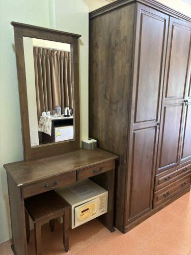 a wooden dressing table with a mirror and a dresser at The Sunshine hostel and hotel in Ko Lanta