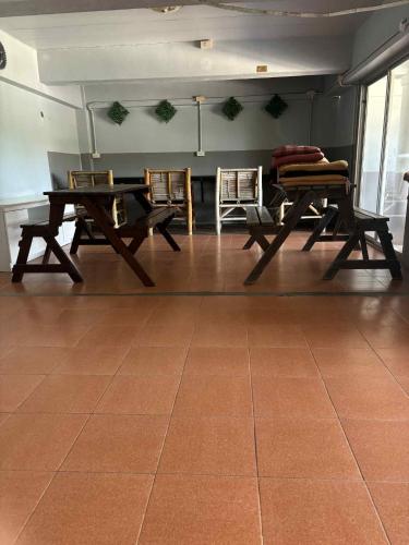 a room with two tables and chairs on a tile floor at The Sunshine hostel and hotel in Ko Lanta