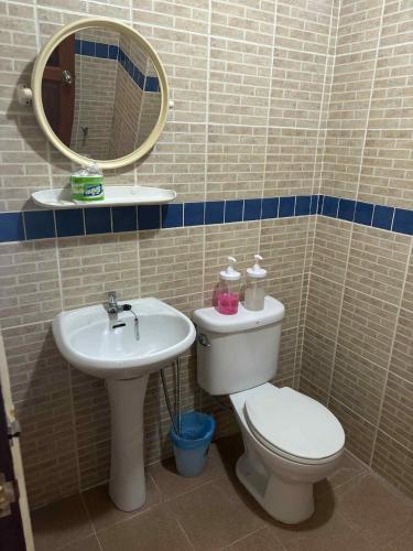 a bathroom with a toilet and a sink and a mirror at The Sunshine hostel and hotel in Ko Lanta