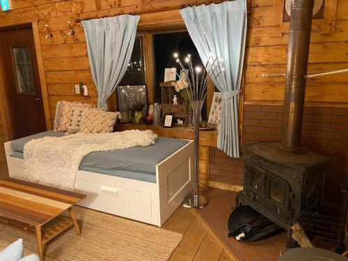 - une chambre avec un lit et un poêle à bois dans l'établissement Trust Maison Hoshizora Resort Shirata - Vacation STAY 83049v, à Higashiizu