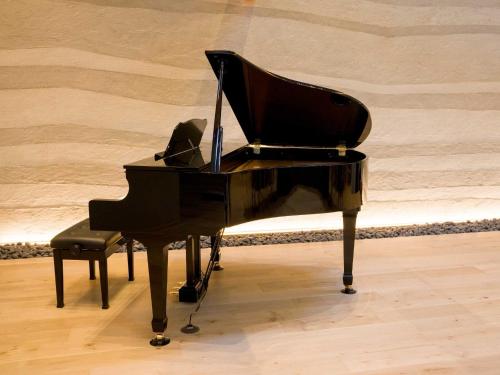 a black piano with a chair next to it at Rakuten STAY VILLA Kamogawa A with Pool and Terrace and sauna Capacity of 12 persons in Kamogawa
