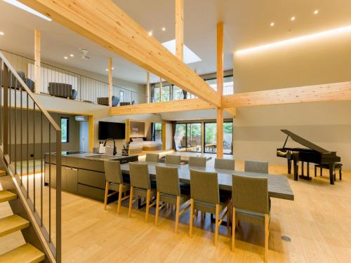a dining room and kitchen with a table and a piano at Rakuten STAY VILLA Kamogawa A with Pool and Terrace and sauna Capacity of 12 persons in Kamogawa
