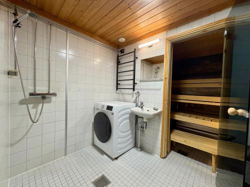 a bathroom with a washing machine and a sink at Holiday Hopukka in Luosto