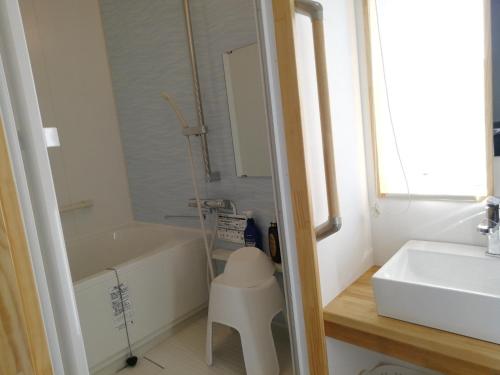 a bathroom with a bath tub and a sink at Naoshima Accommodation Menjuku Ura - Vacation STAY 25944v in Naoshima