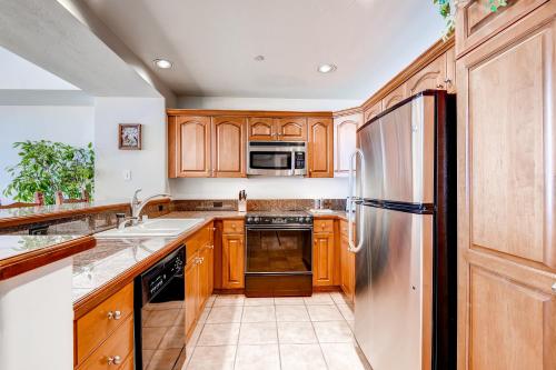 a kitchen with wooden cabinets and a stainless steel refrigerator at St. James Place in Beaver Creek