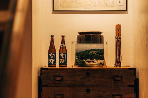 a table with three bottles and a picture on it at Ooka Tsuji - tsuji-oooka - - Vacation STAY 01156v in Chikuma