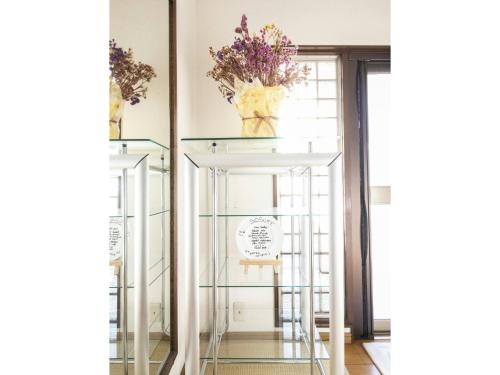 a glass display case in a room with flowers on it at Minpaku Yamamoto - Vacation STAY 13870 in Izumiotsu
