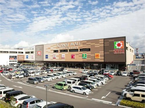 a parking lot with cars parked in front of a mall at Minpaku Yamamoto - Vacation STAY 13870 in Izumiotsu