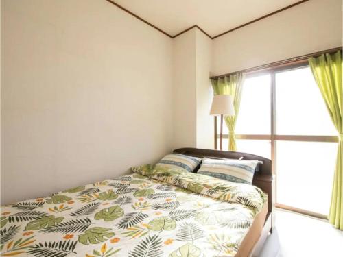 a bedroom with a bed and a window at Minpaku Yamamoto - Vacation STAY 13869 in Izumiotsu