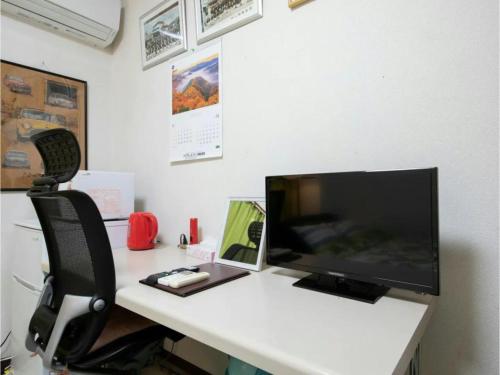 a computer monitor sitting on a desk with a chair at Minpaku Yamamoto - Vacation STAY 13869 in Izumiotsu