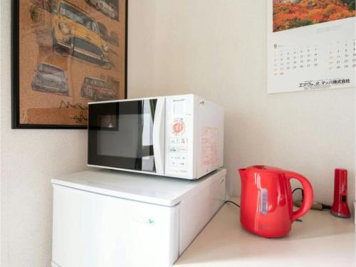 a microwave oven sitting on top of a refrigerator at Minpaku Yamamoto - Vacation STAY 13869 in Izumiotsu