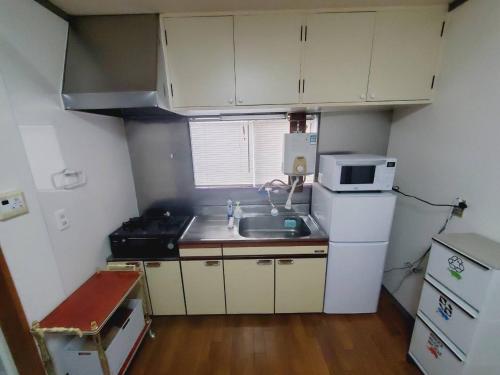 eine kleine Küche mit Spüle und Mikrowelle in der Unterkunft Corp Temma - Vacation STAY 08144v in Takayama