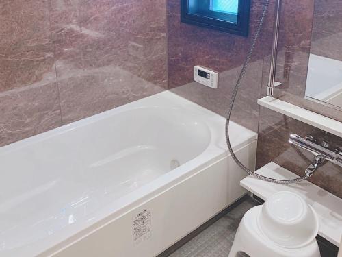 a bathroom with a white tub and a toilet at ＥＵＲＯＰＥＡＮ ＨＯＵＳＥ ＲＥＩＳＥＮ - Vacation STAY 10505v in Fukuoka