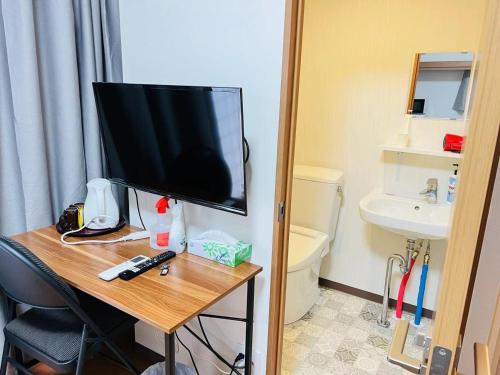 a room with a television on a table with a bathroom at FUKUINN - Vacation STAY 19203v in Takamatsu