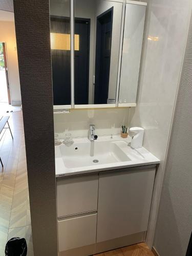 a bathroom with a white sink and a mirror at Guest House Numazu Port - Vacation STAY 18050v in Numazu