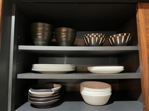 a shelf with bowls and plates in a cabinet at Guest House Numazu Port - Vacation STAY 18050v in Numazu