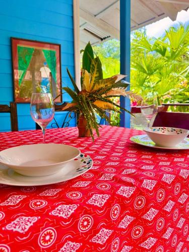 a red table with plates and glasses on a red table cloth at Villas Itaita Beach Cabins in Punta Uva