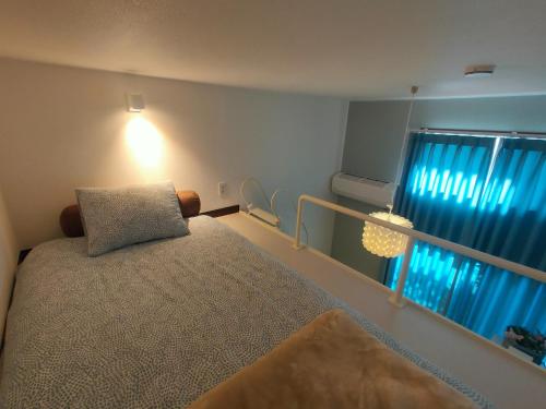 una camera da letto con un letto e una finestra con tende blu di Glen Stage 102 - Vacation STAY 13962 a Saitama