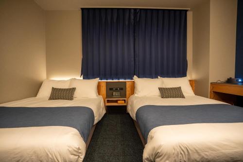 a hotel room with two beds and a window at UU HOME - Vacation STAY 28498v in Biei