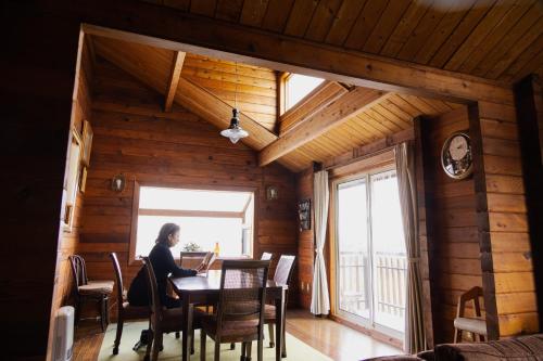 a woman sitting at a table in a room with a window at Renesto aHOLIDAYHOME - Vacation STAY 27971v in Kobe