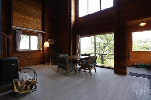 a dining room with a table and chairs and windows at Renesto aHOLIDAYHOME - Vacation STAY 27907v in Kobe