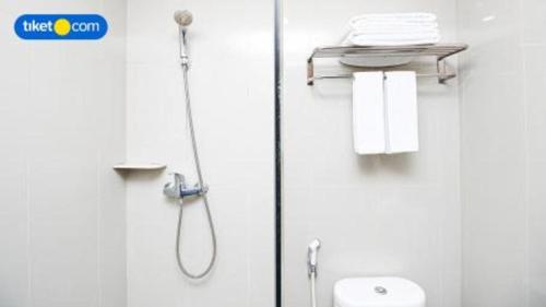 a shower in a bathroom with a toilet and towels at Asialink Premier in Karawang