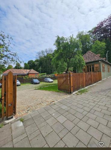 a house with a wooden fence and a driveway at The Throne - M Museum Hotel in Sighişoara