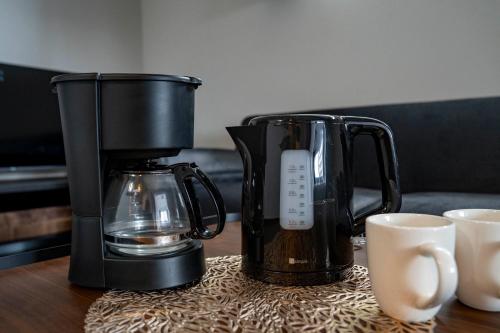 a coffeemaker and a coffee maker on a table with cups at Starlight in Sapporo