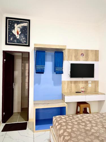 a bedroom with a bed and a tv on a wall at Hotel Asia Express in Lembang