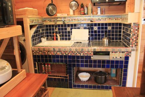 eine kleine Küche mit einem Waschbecken und einer blau gefliesten Wand in der Unterkunft Farm Log Cottage Blueberry Annabel - Vacation STAY 36333v in Ito