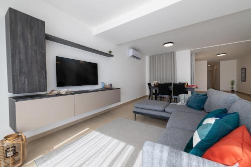 a living room with a couch and a tv at Luxury Apartment Valley Views C5 in Xagħra